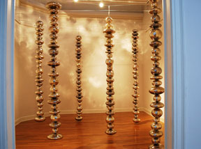 view of back gallery with six hanging sculptures of stacked glass orbs