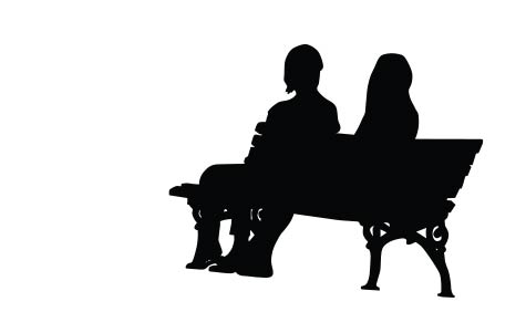 Silhouette image of two people sitting on a bench