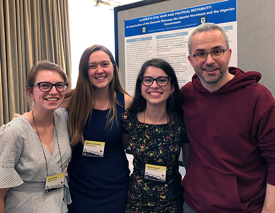 Seniors Sophia Angeletti, Shannon Armstrong, and Jenna Fischer with their professor Yiğit Akin