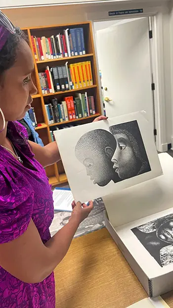 Professor Mia L. Bagneris at the Amistad Research Center with a print by Elizabeth Catlett