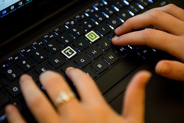 Picture of a keyboard with a stylized / branded Tulane T and U stickers on the corresponding keys. photo Sally Asher