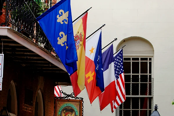 Flags line the balcony over Tony Seville's Pirate's Alley Cafe at the corner of Cabildo Alley and Pirate's Alley. photo Paula Burch-Celentano