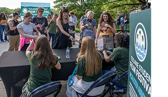 Attendees checking in at an outdoor Tulane Student Film Festival registration table.
