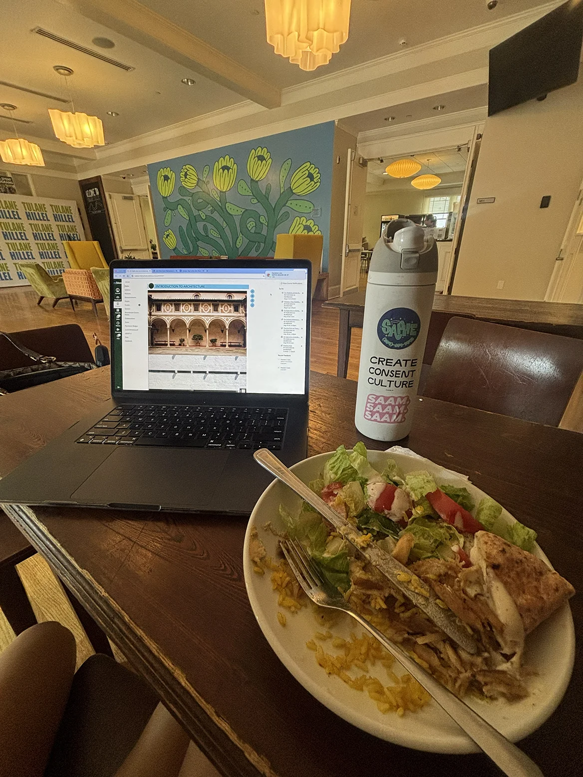 Lunch, a laptop, and a water bottle on a table at Rimon