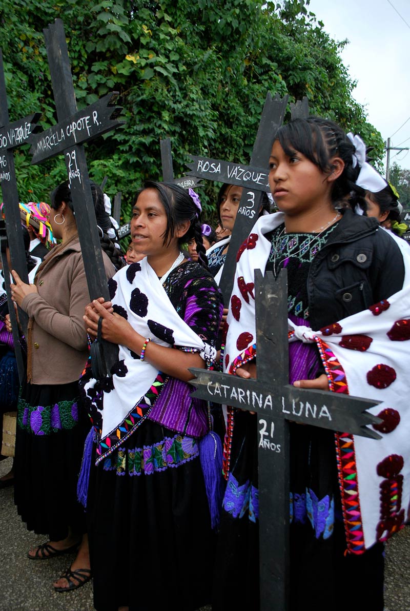 People carrying crosses bearing the names and ages of some of the massacred