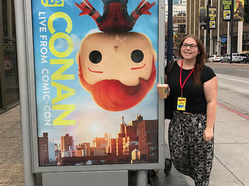 Molly Noonan poses with a billboard promoting the Conan Show