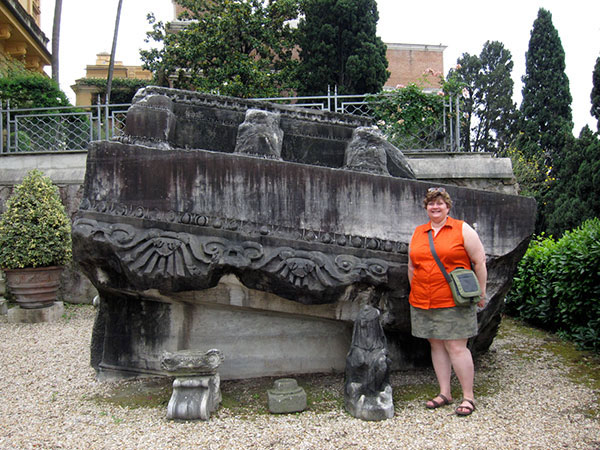 Susann Lusnia standing next to a gigantic marble pediment block on the Quirinal hill