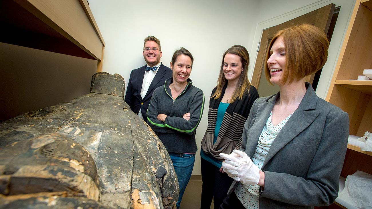 A 3,000-year-old Egyptian coffin gets a closer look by Melinda Nelson-Hurst, research associate in anthropology, and students (from left) Jules Paris Vetter, Maria Arabie and Elise Hanemann. Photo Paula Burch-Celentano | Tulane University 