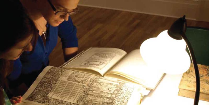 Students examine a fifteenth-century printed book.