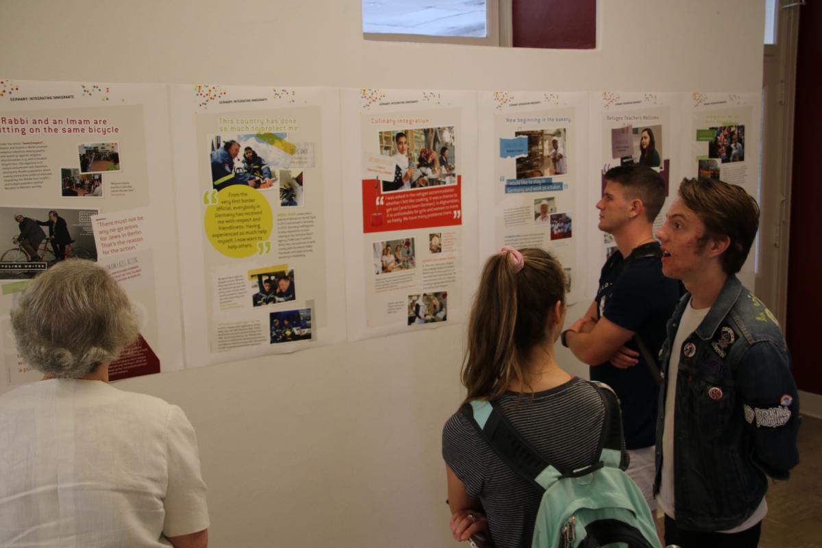 Students take in and discuss the Integrating Immigrants exhibit