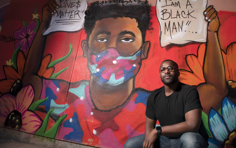 Alumnus Frederick Bell in front of "I Am A Black Man," a mural by Jarrad McKay
