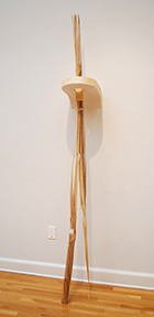 sculpture that leans against wall and comes out of wall, with wood that has softer parts carved away