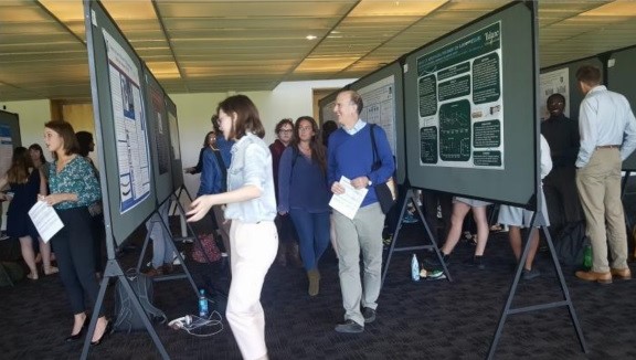 Meg Roppolo shows her poster to Prof. Brancaforte and students from German 4800/6800