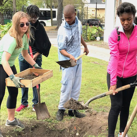 Urban Gardening student Ella Catherine Strahan prepares a new garden bed with St. Anna's youth. 