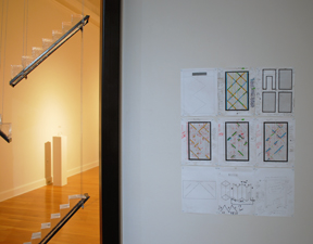 partial view of back gallery with stair-like components in glass, with color sketches and diagrams for the installation
