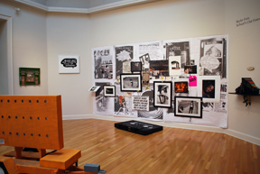 gallery installation view with wall densely collaged 