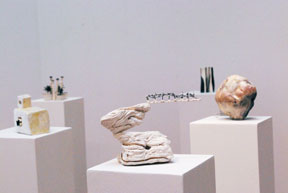 five pedestals in configuration with abstract ceramic sculptures on each pedestal