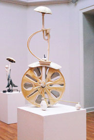 tall ceramic sculpture resembling a unicycle on pedestal