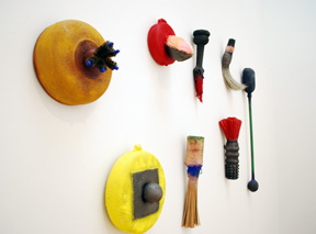 wall of small sculpture made of industrial material and resembling tools and organic forms