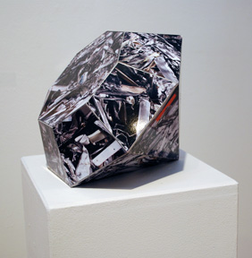 sculpture shaped like cut gem with each facet covered in color photograph of hardware