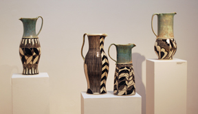 series of four tall ceramic pitchers with black and white sgraffito decoration