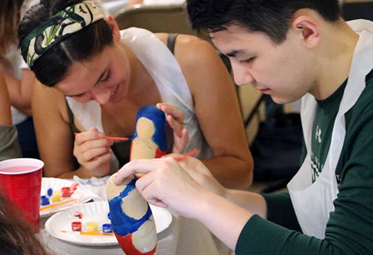 Tulane students painting matryoshka dolls