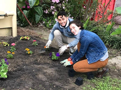 Emma Hopkins and Miko Solis plant flowers