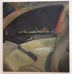interior of car at night with lights from oil refinery visible in distance