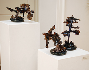 three small-scale glass trees made of brown glass
