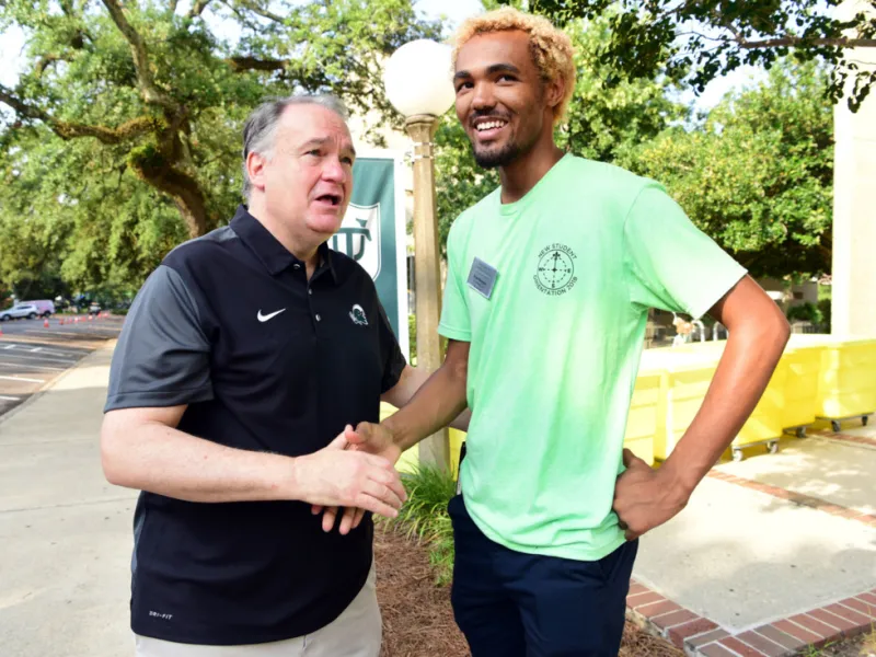 Tulane President Mike Fitts speaks with student Wave Leader and Director Evan Doomes