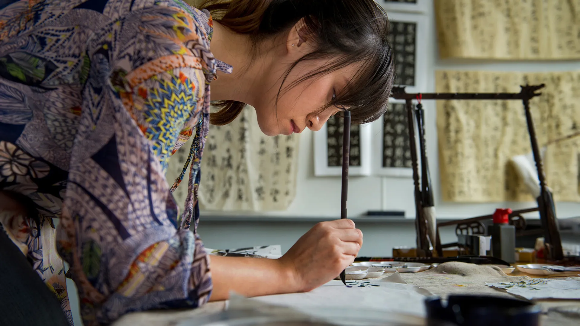 Student practicing calligraphy with brush and ink. Asian Studies at Tulane.