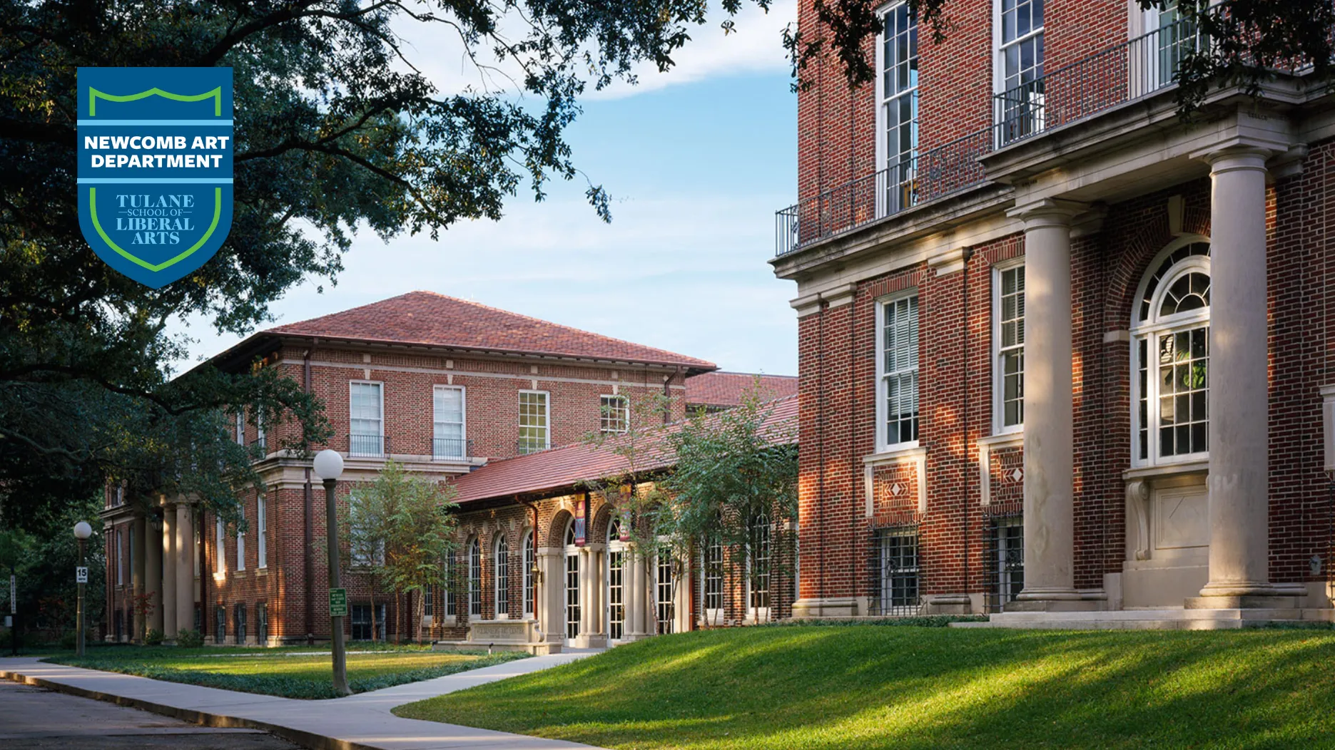 exterior view of the Woldenberg Art Center, a complex of red brick buildings with live oak tree cano