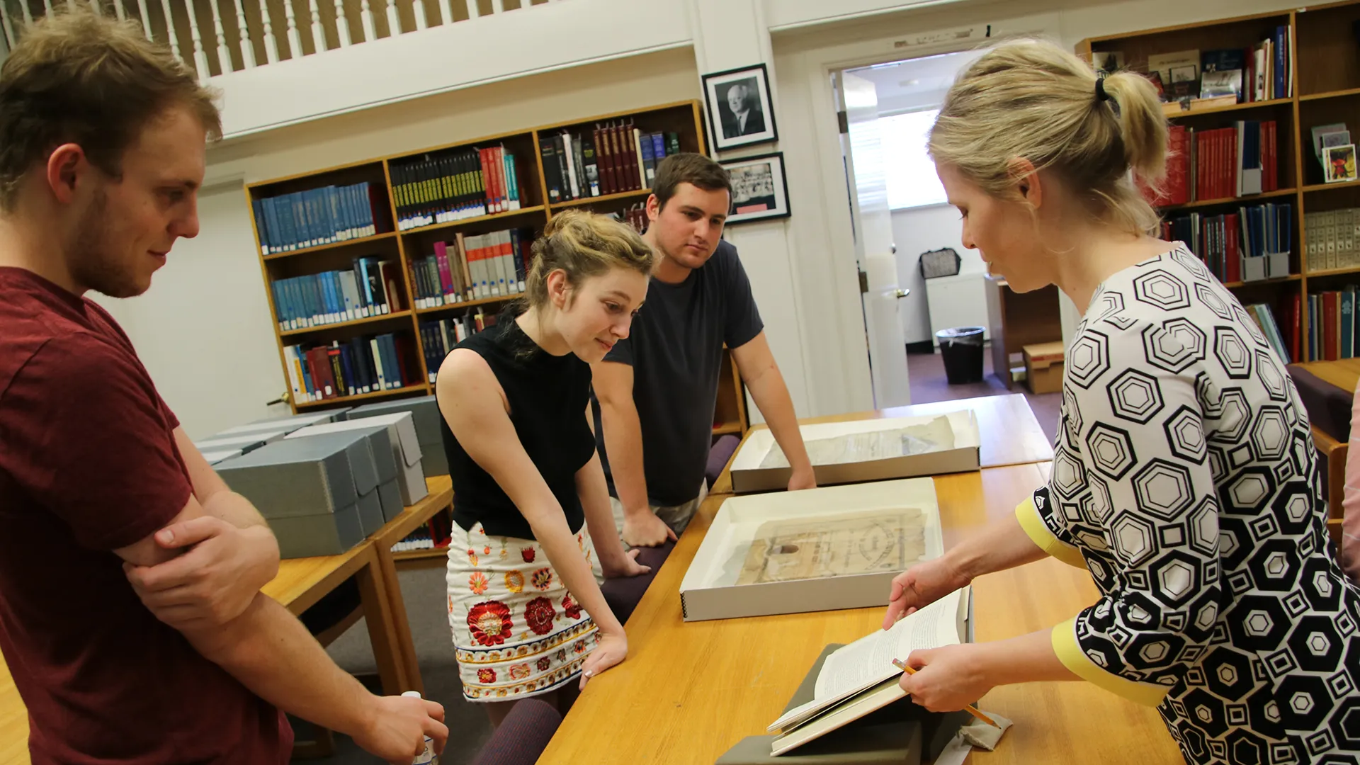 Teacher and Students Examine Books at Tulane