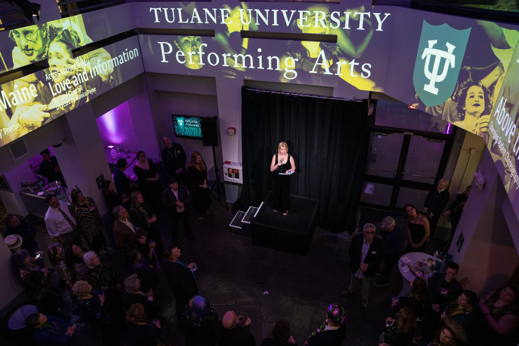 Invited guests listen to Associate Dean on the Performing Arts Leslie Scott announces the upcoming s